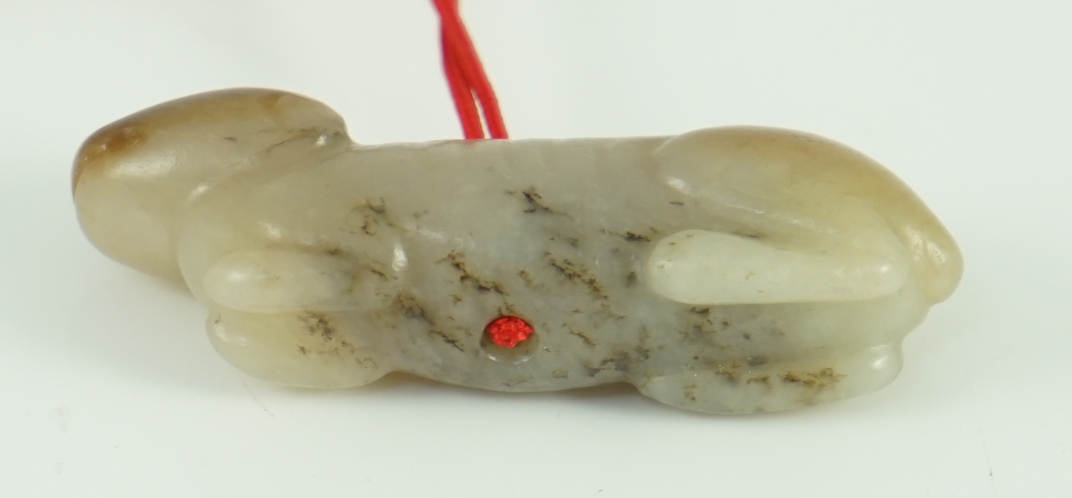 A Chinese pale grey and russet jade figure of a hound, probably Song dynasty, 4.9 cm long